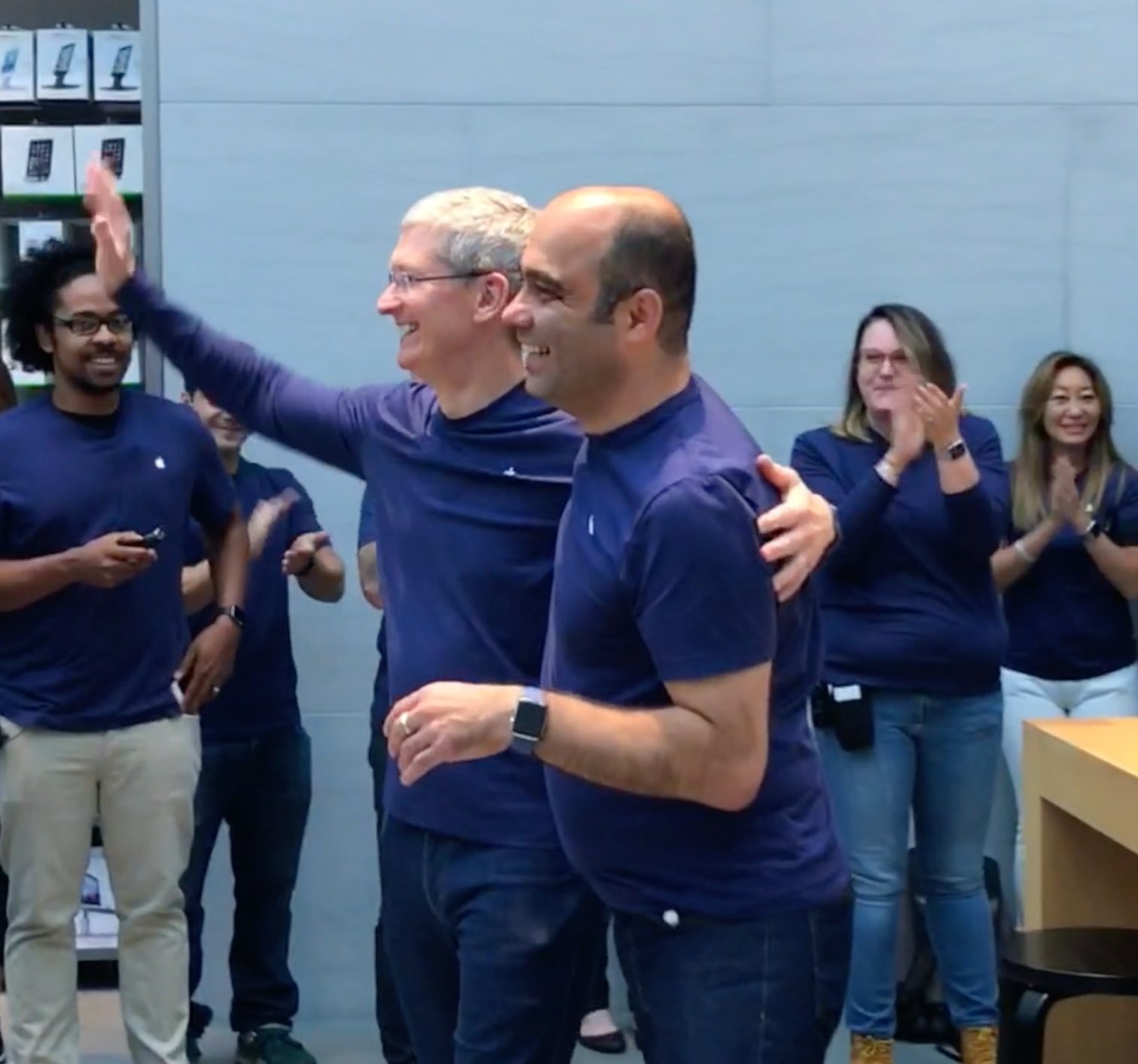Tim Cook, arm raised in celebration, with Baha Cinar in an Apple Store as the team applauds